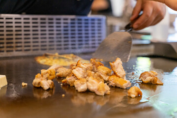 The chef is stirring the delicious Teppanyaki chicken and the aroma is overwhelming