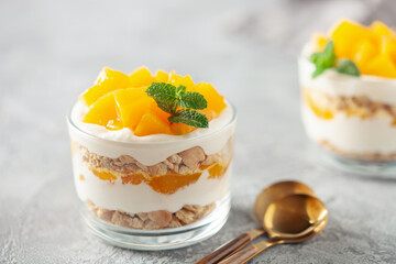 Delicious mango float cake in glasses on wooden board. Filipino sweet cuisine
