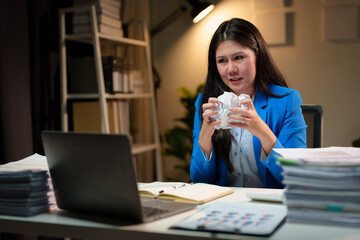 Fototapeta premium Angry Asian businesswoman or female office worker tearing and crumpling a broken document. Not correct as required Made a mistake while working at her desk. working overtime Office syndrome concept.