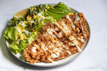 Crispy breaded chicken breast with fresh salad.