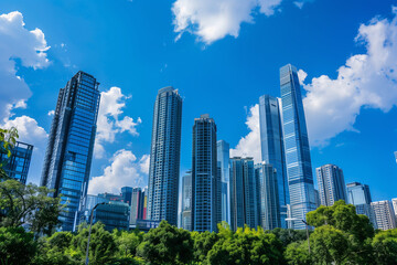 Fototapeta premium Skyscrapers Reaching into a Bright Blue Sky with White Clouds on a Sunny Day