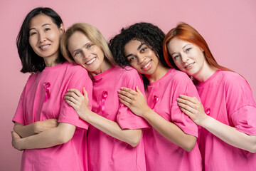 Diverse group of women embracing in pink for breast cancer awareness