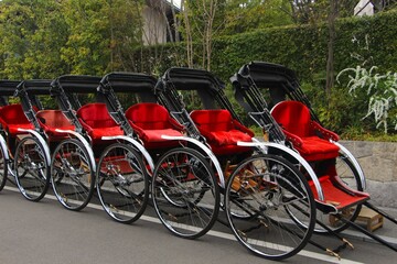 Fototapeta premium Many black and red rickshaws in a row in Kyoto Japan