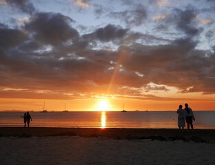 Fototapeta premium フィジーのナンディのワイロアロアビーチの夕日を見る親子とカップル