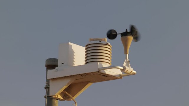 The weather vane of the weather station rotates in the wind