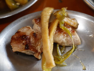 Korean spicy noodle dish with vegetables and yeolmu kimchi in metal bowl, side dish of Korean bbq