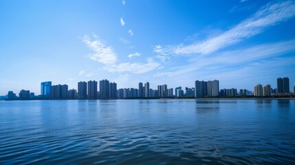 Obraz premium Against a blue sky background, the upper part displays the city's light and shadow effects, while the lower part depicts the reflection of the water surface and the city