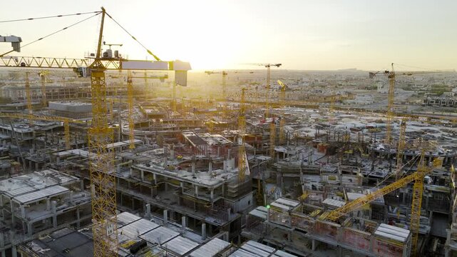 Drone view of Mega construction of Saudi Arabia on the sunset with plenty of cranes 