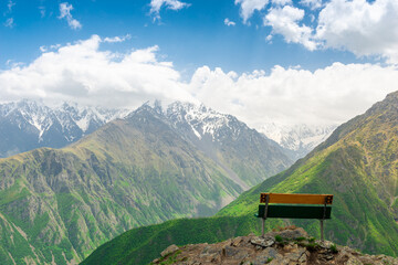 A wooden bench in the mountains overlooking the beautiful picturesque mountains of the North Caucasus. Russia
