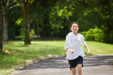 夏休みの公園で楽しく遊んでいる小学生の女の子の様子