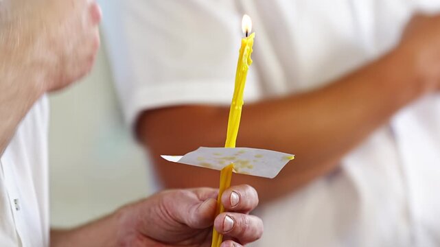 People hold church candles in their hands at a service in the church. Orthodox traditions and rituals.