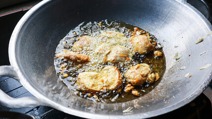 Close up of Tofu being deep fried in a wok with much oil. Deep Fried Food in a Wok. The Process of Cooking Fried Tofu Background.