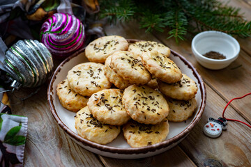 Cheese cookies on a white plate on a wooden table. Cheese crackers for breakfast. Close-up