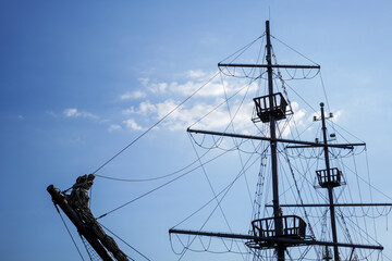 Silhouette of a pirate ship against the blue sky. Three observation points (stork nests).Copy space
