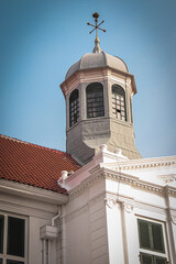 Close-up of Fatahillah Museum's iconic octagonal tower with a grey dome and golden weather vane....