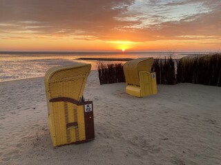 Sonnenaufgang an der Nordsee am Strand von Cuxhaven mit Strandkörbe