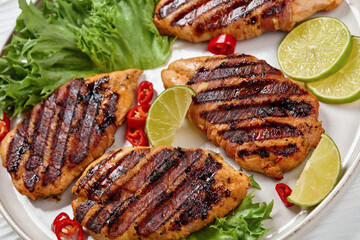 grilled chicken breasts wrapped in bacon on plate