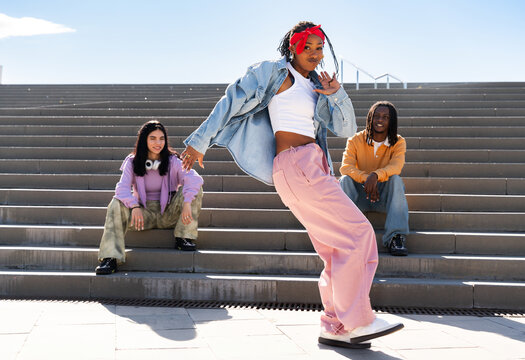 Young group of multiethnic hip-hop dancers wearing colorful urban streetwear dancing - Stylish multiracial rap crew portrait in the city
