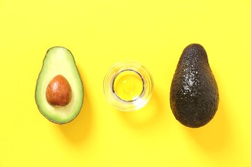 Green avocado with oil on a color background
