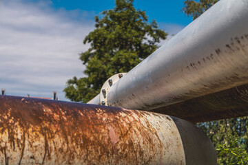 usty pipes, screws, rivets. industrial landscape against the background of blue sky and white clouds