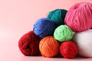 Pile of different colorful yarns on pink background, closeup. Space for text