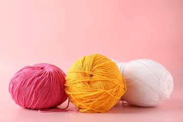 Different colorful yarns on pink background, closeup. Space for text