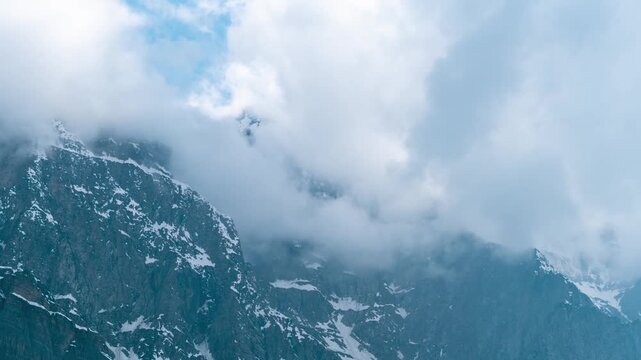 4K Timelapse shot of dark stormy clouds covering the snowy Himalayan mountain peaks as seen from Khangsar village in Lahaul Valley, Himachal Pradesh, India. Clouds above the snowy Himalayas.