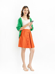 Cheerful Asian woman wearing a green shirt smiles as she holds a smartphone against a white background.