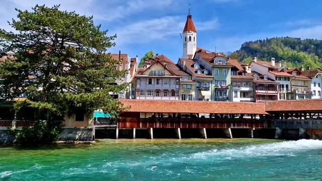 4K Video of Thun Old Town with Medieval Castle and Alps. Scenic View of River Aare with Historic Wooden Bridge and Rushing Water. Switzerland Travel Destination. High Quality Footage with Audio.