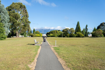 Man pulling a luggage and walking on the path. Te Anau. South Island. New Zealand.