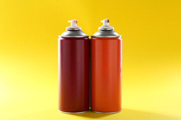 Two spray paint cans on yellow background