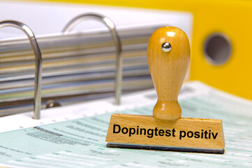 Ein Holzstempel ist beschiftet mit dem Aufdruck: Dopingtest positiv