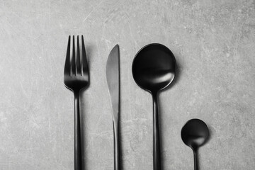 Stylish cutlery on grey table, flat lay