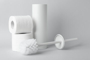 Obraz premium Toilet brush, holder and rolls of paper on white background