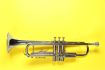 Obraz premium One trumpet on yellow background, top view. Space for text