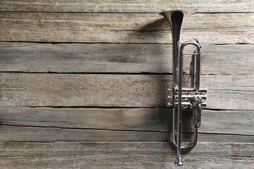 Fototapeta premium Trumpet on wooden table, top view. Space for text