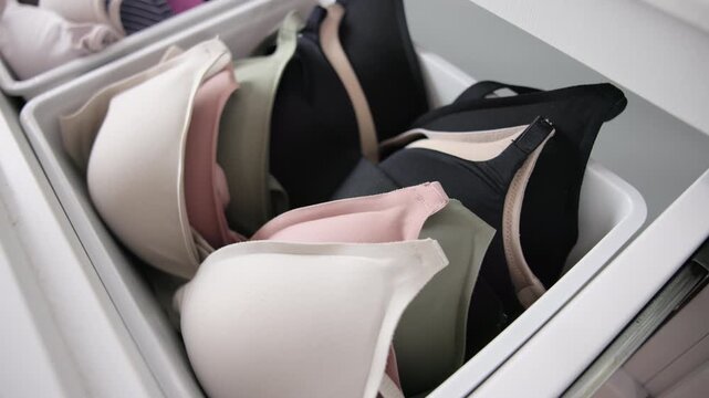 Close-up no people arrange stack undies manage used old wireless bra neat basket box clean house closet shelf eco woman care. Go green wife home chores zero waste reduce underwear cup fabric issue.