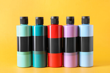 Acrylic paints of different colors on orange background