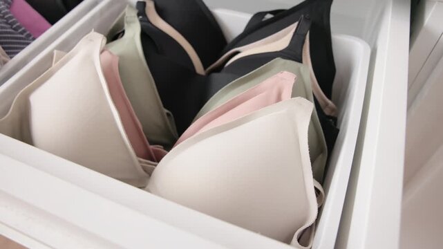 Close-up no people arrange stack undies manage used old wireless bra neat basket box clean house closet shelf eco woman care. Go green wife home chores zero waste reduce underwear cup fabric issue.