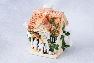 A kettle in the shape of a house. Antique porcelain tea pot