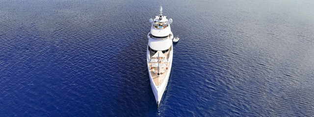 Aerial drone ultra wide top down photo with copy space of luxury yacht with wooden deck anchored in...