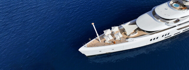 Aerial drone ultra wide top down photo with copy space of luxury yacht with wooden deck anchored in Aegean island with deep blue sea, Greece © aerial-drone