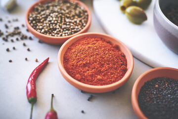 Assortment, bowl and spices on table for ingredients, powder and board for sensory appeal with culinary. Organic, condiment and flavor for cooking with coriander, black pepper and curry for seasoning