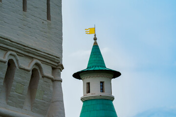 Architectural details of a historic white tower and green-roofed turret