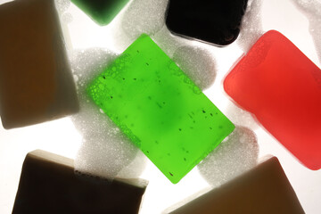 soap of different colors and sizes on a light background with foam