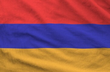 Armenia flag depicted on folded wavy fabric of old cloth close up