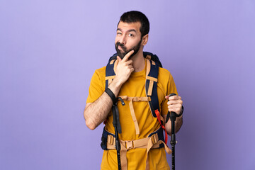 Caucasian handsome man with backpack and trekking poles over isolated background thinking