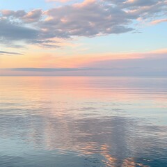 Fototapeta premium A serene sunset over tranquil lake waters with pastel clouds reflecting on calm water and a soft pink sky, evoking natural beauty.