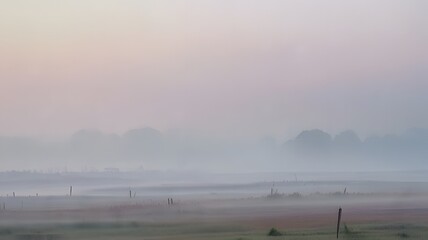 Naklejka premium A distant horizon shrouded in mist with soft, pastel colors and faint, diffused light filtering through the misty sky.