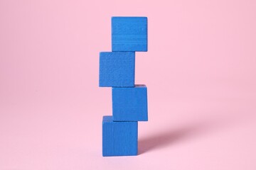 Stack of blank blue cubes on pink background